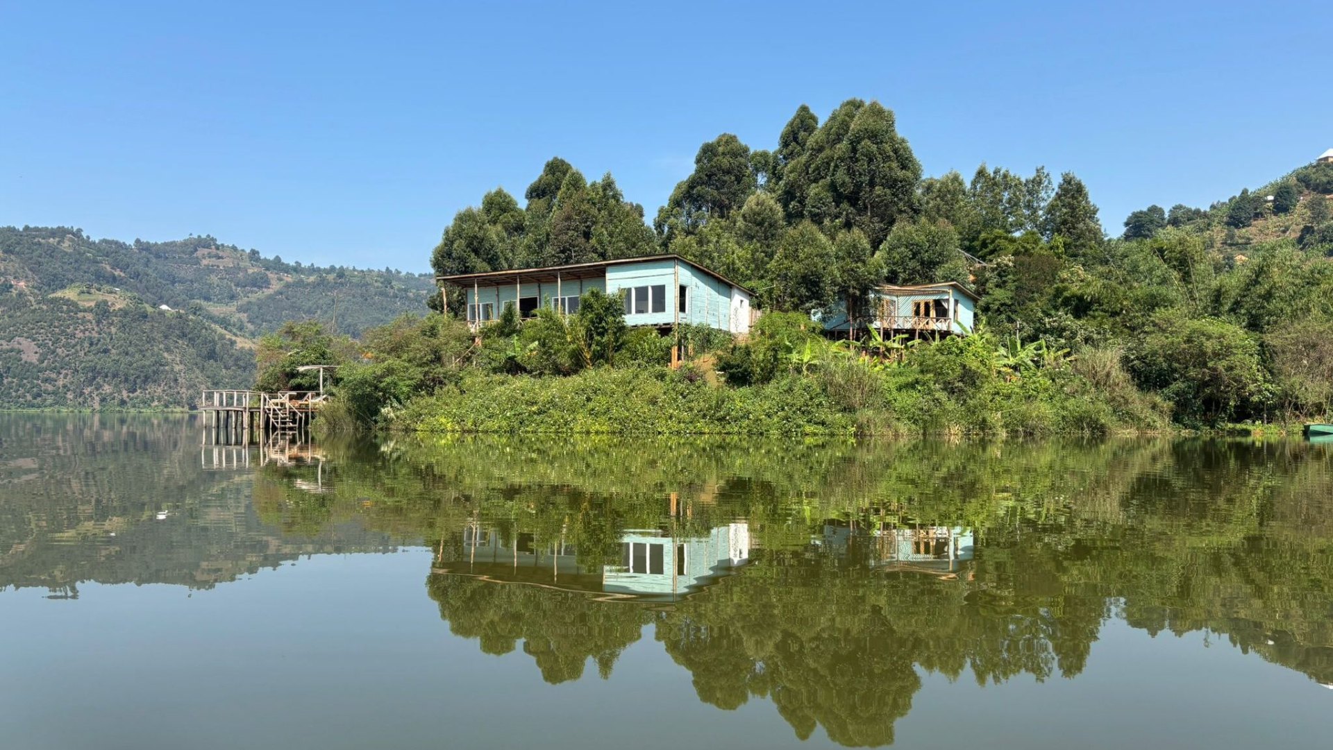 Blue lakeside cabins reflected in Lake Mulehe